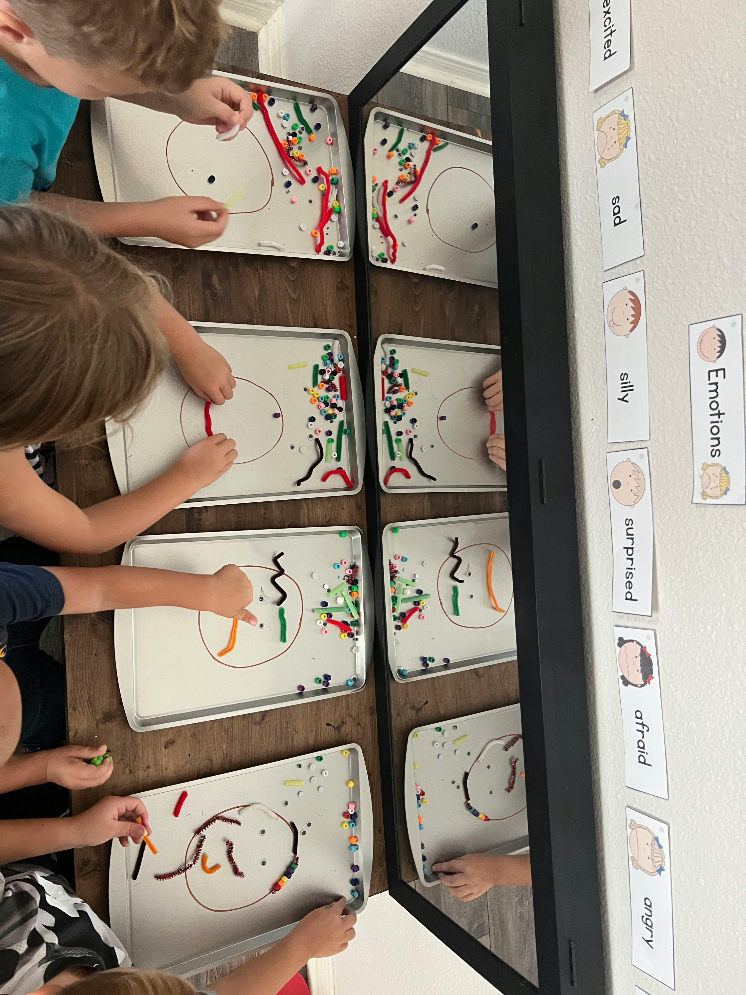 Children creating art with colorful materials on trays
