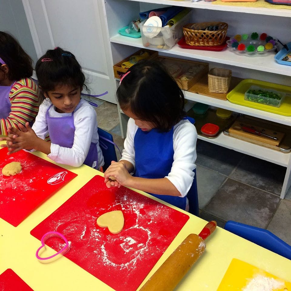 Two children making heart-shaped cookies