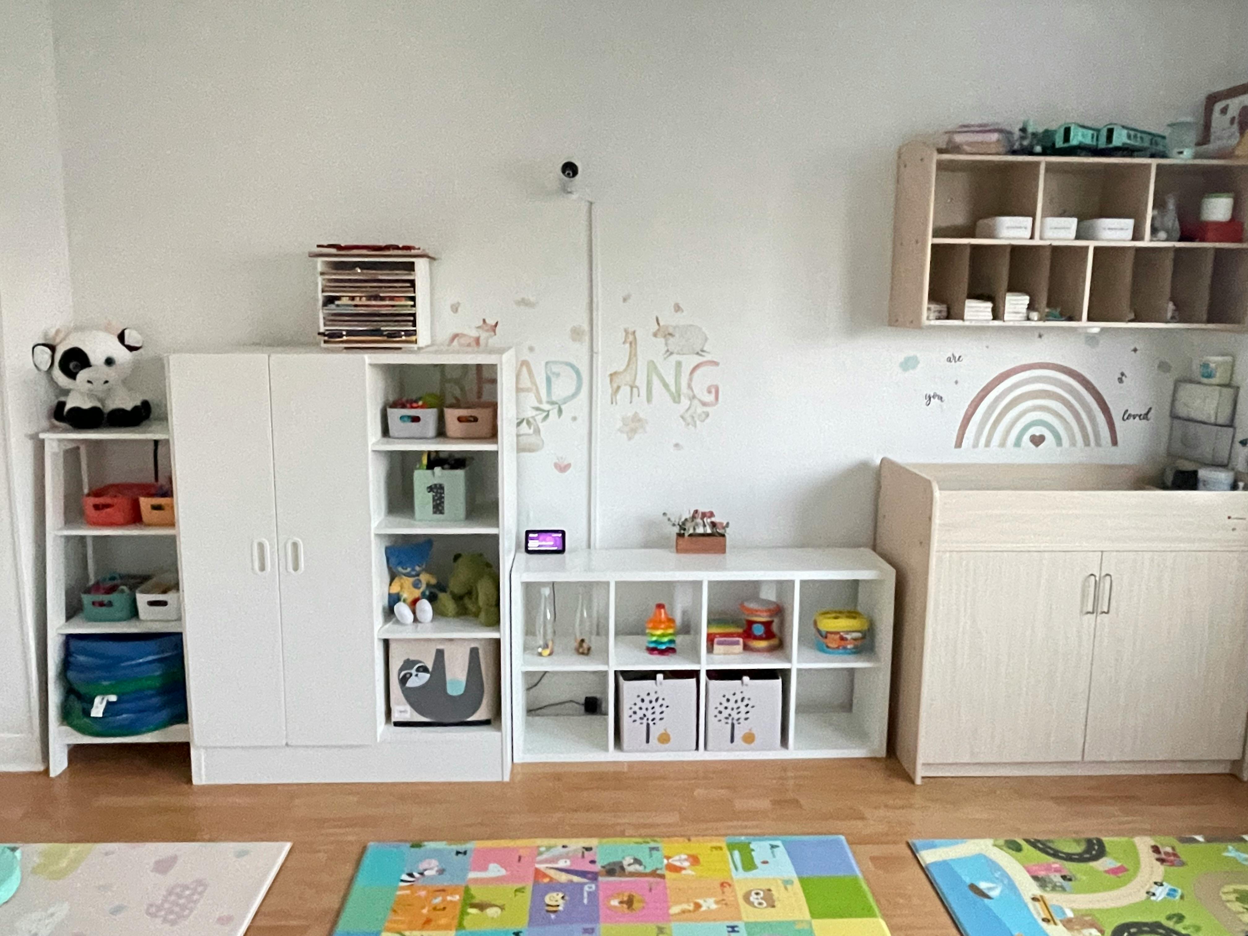 Classroom with white shelves, cabinets, and colorful playmats