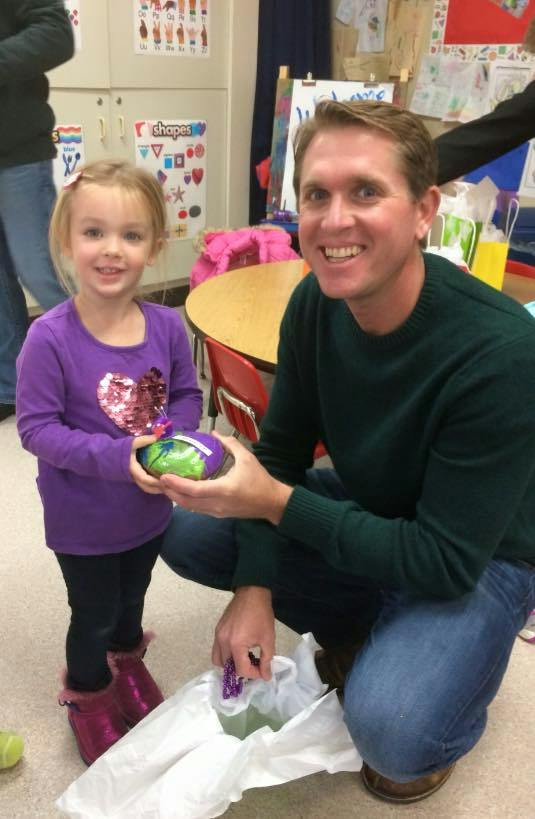 Adult and child holding a decorated egg