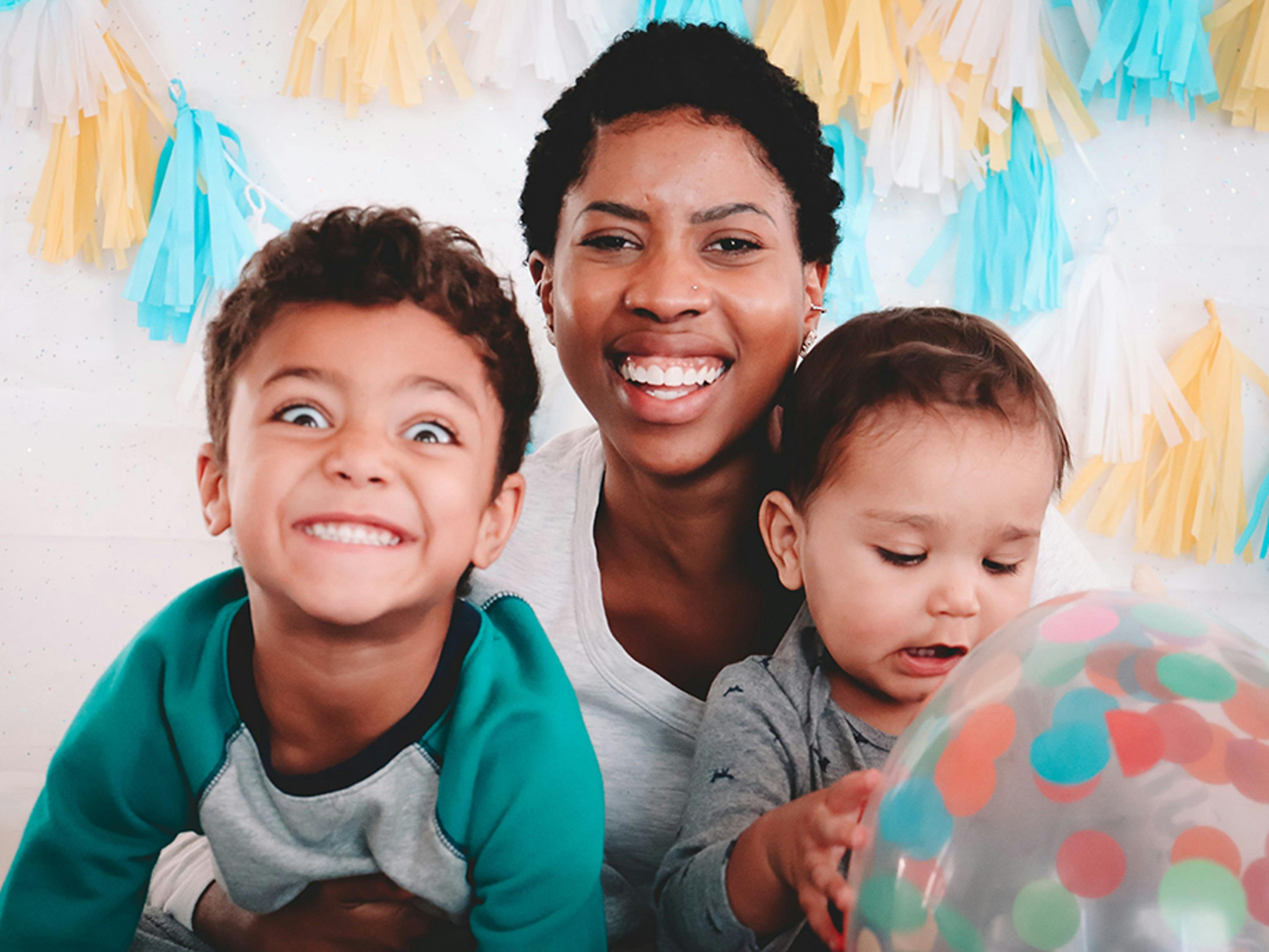Person with two children, one child making a silly face