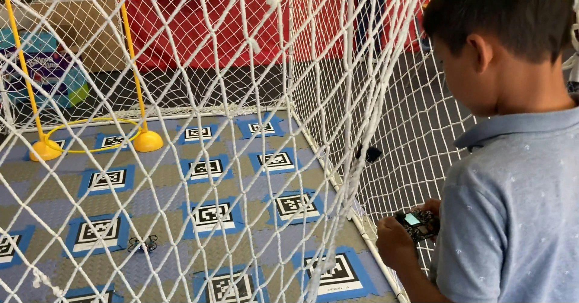 Child playing a game with a controller behind a net