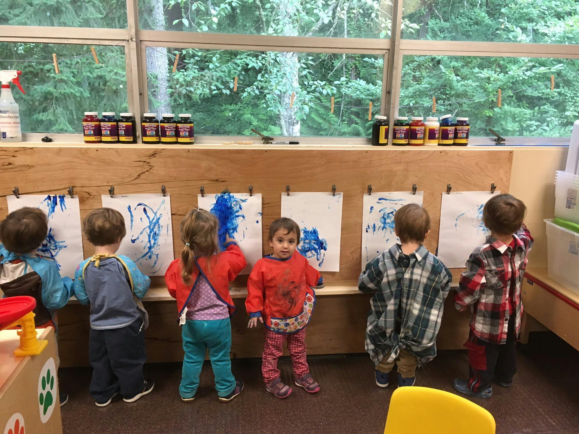 Children painting at easels in a classroom