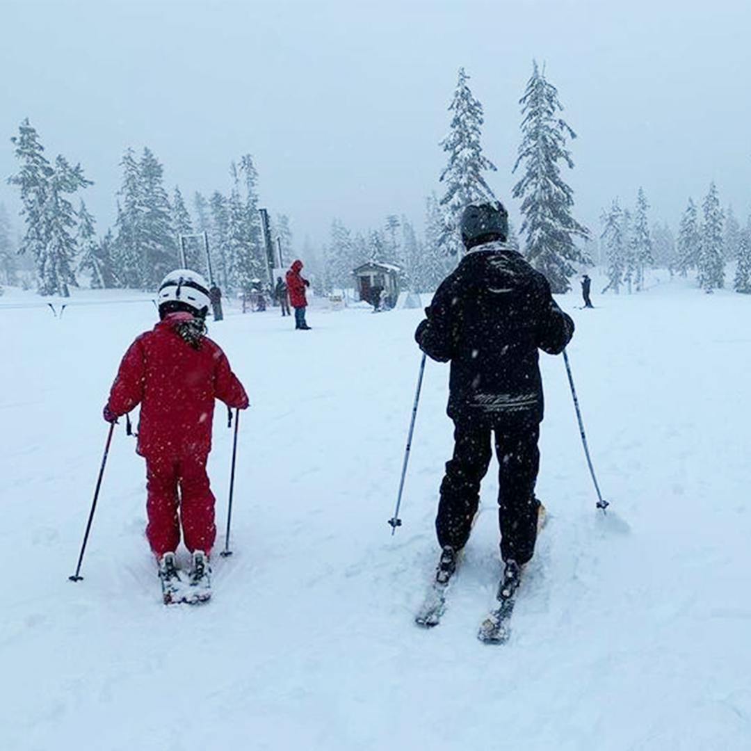 Two people skiing in a snowy landscape
