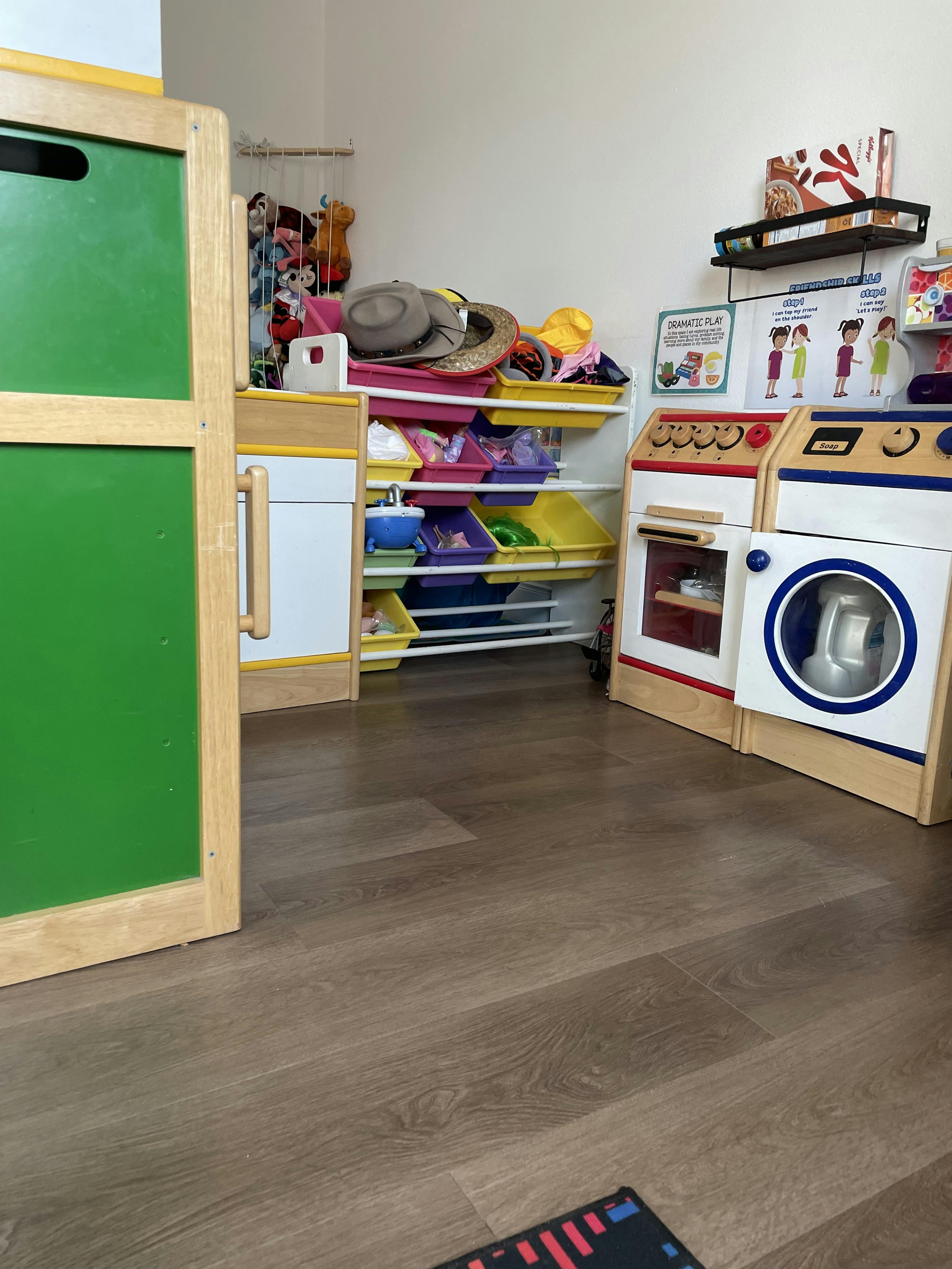 Child's playroom with toy storage bins and miniature kitchen appliances