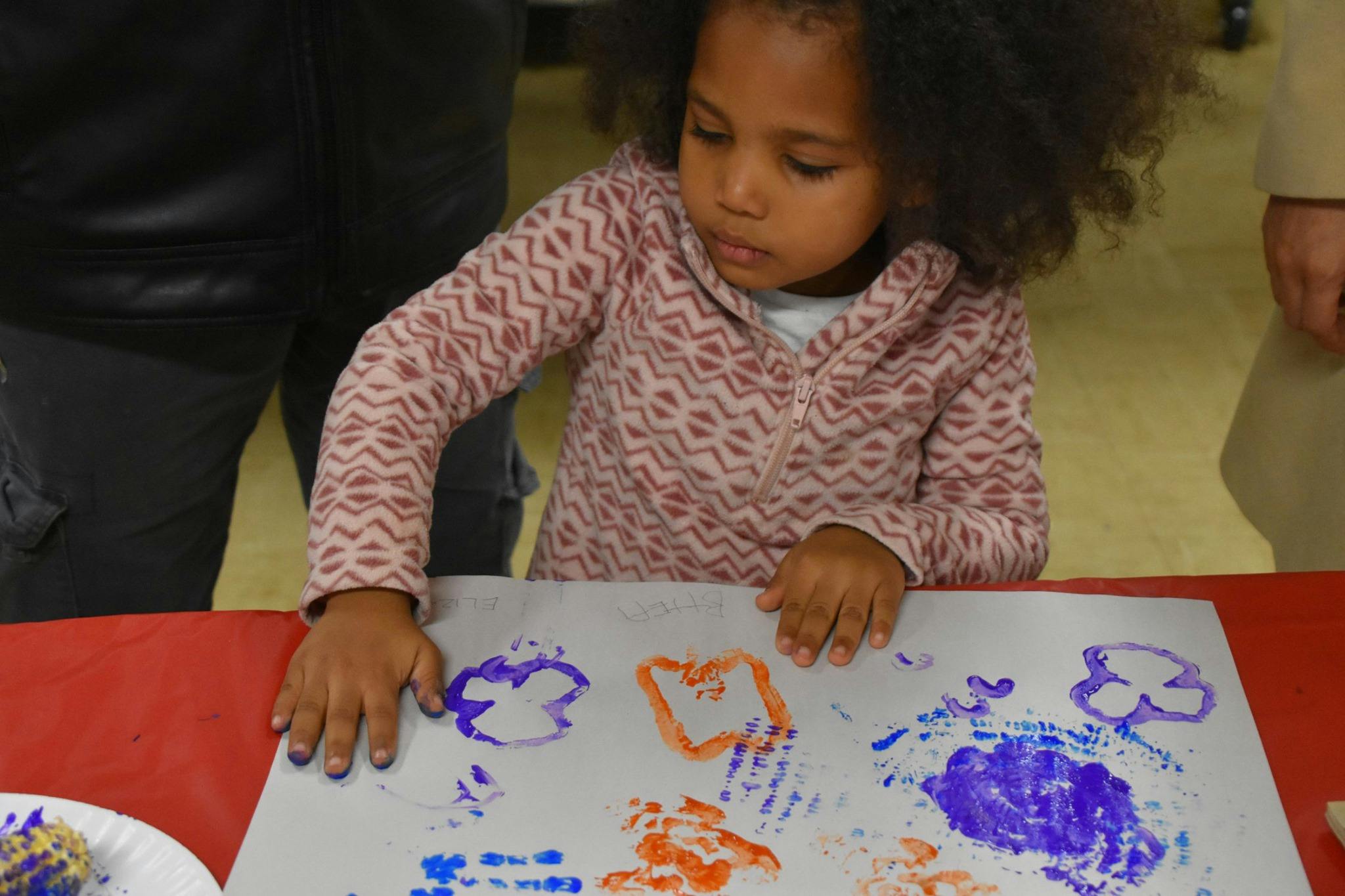 Child making handprint art on paper