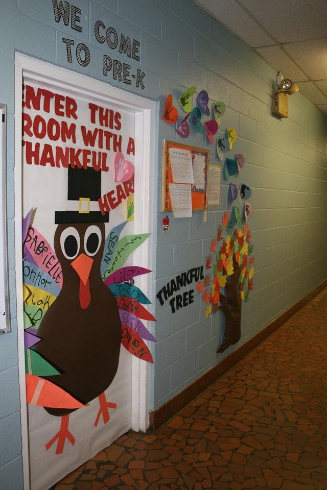 Thanksgiving turkey decoration on a door with text "ENTER THIS ROOM WITH A THANKFUL HEART"