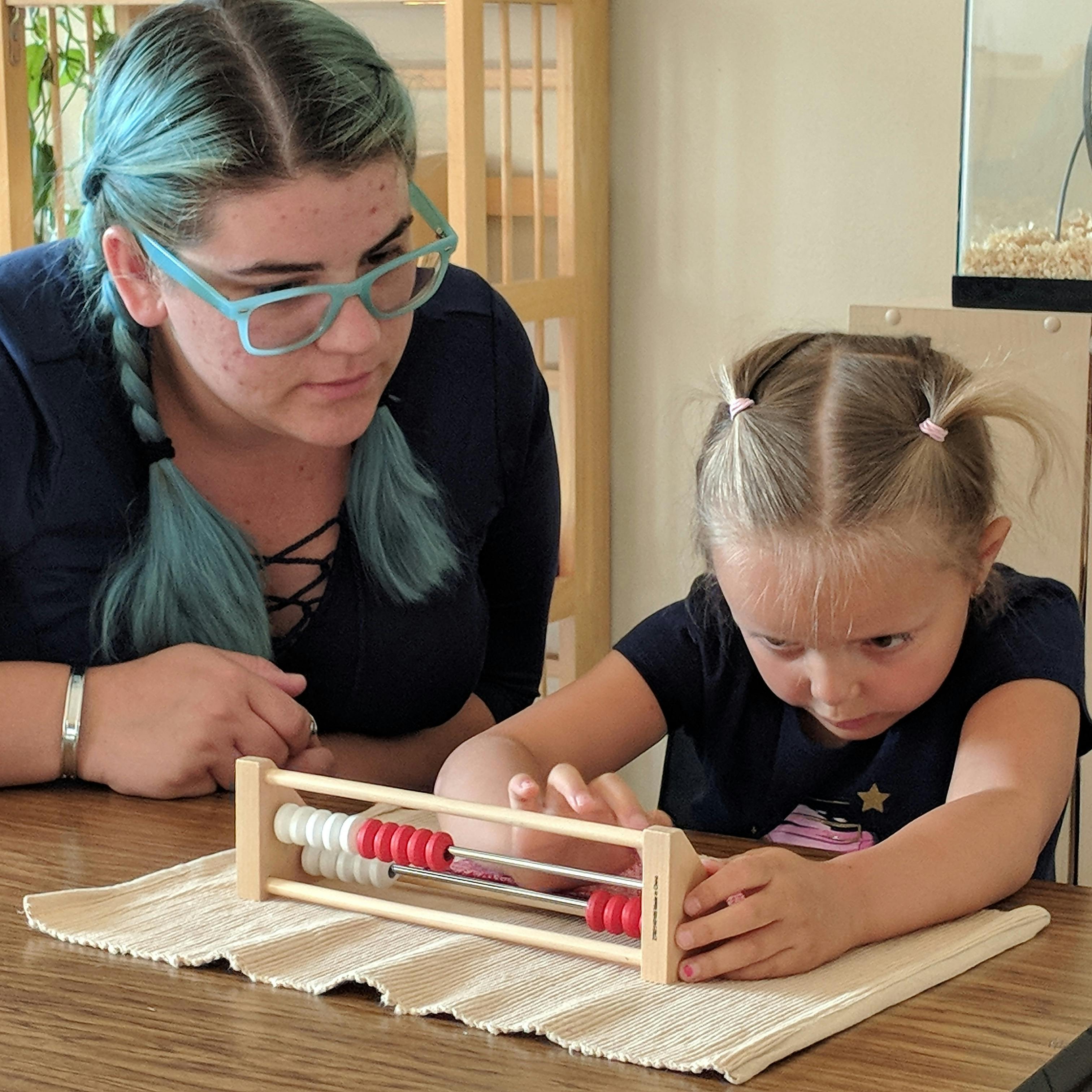 Person and child looking at an abacus