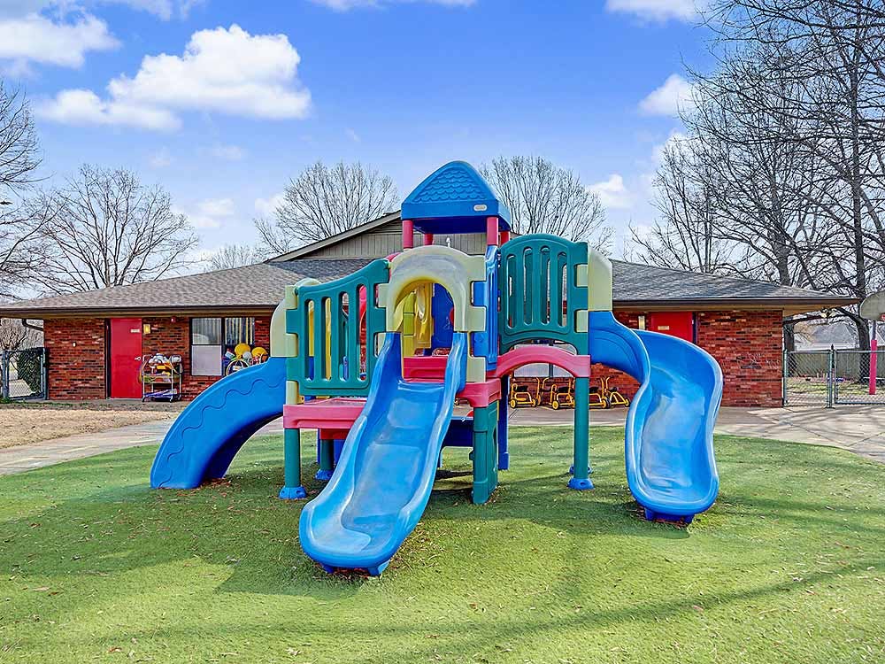 Colorful playground with multiple slides on artificial turf