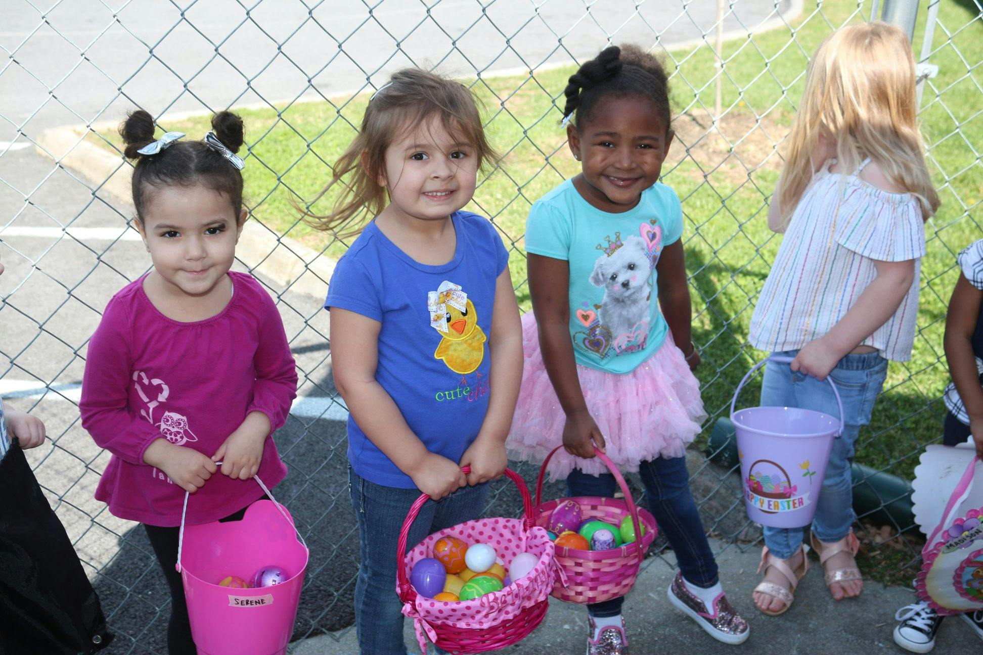 Children holding baskets and buckets with colorful eggs