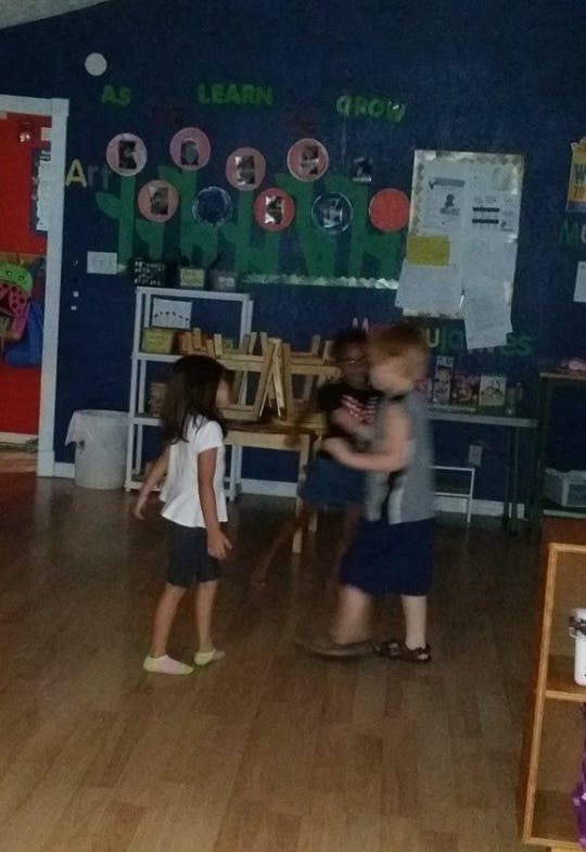 Three children playing in a classroom