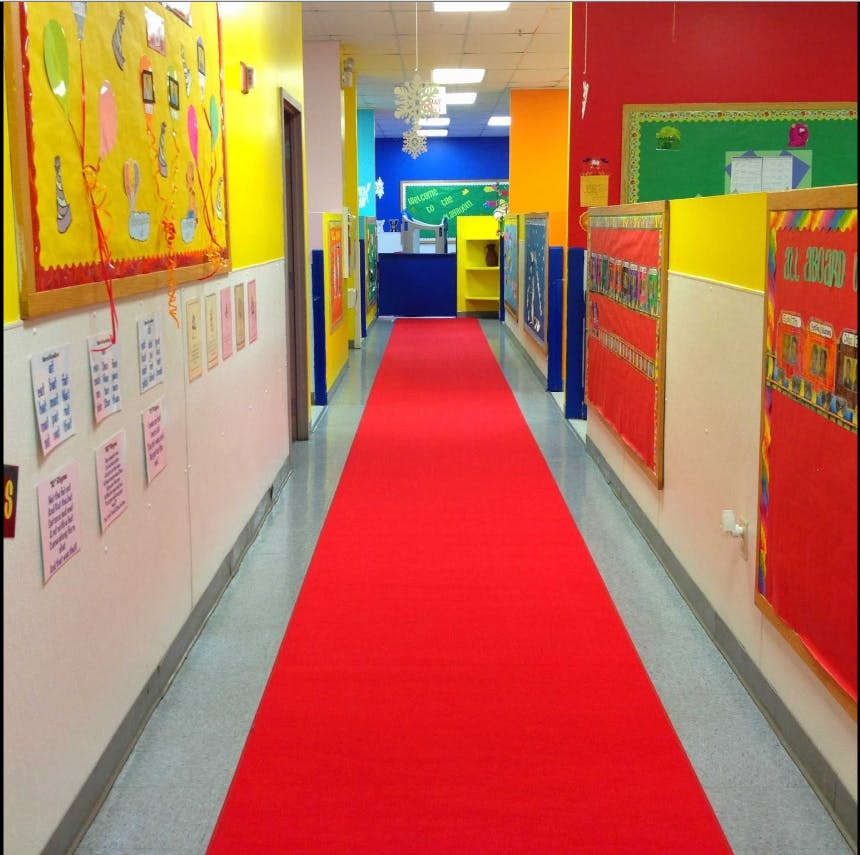 Hallway with a red carpet and colorful walls decorated with children's artwork