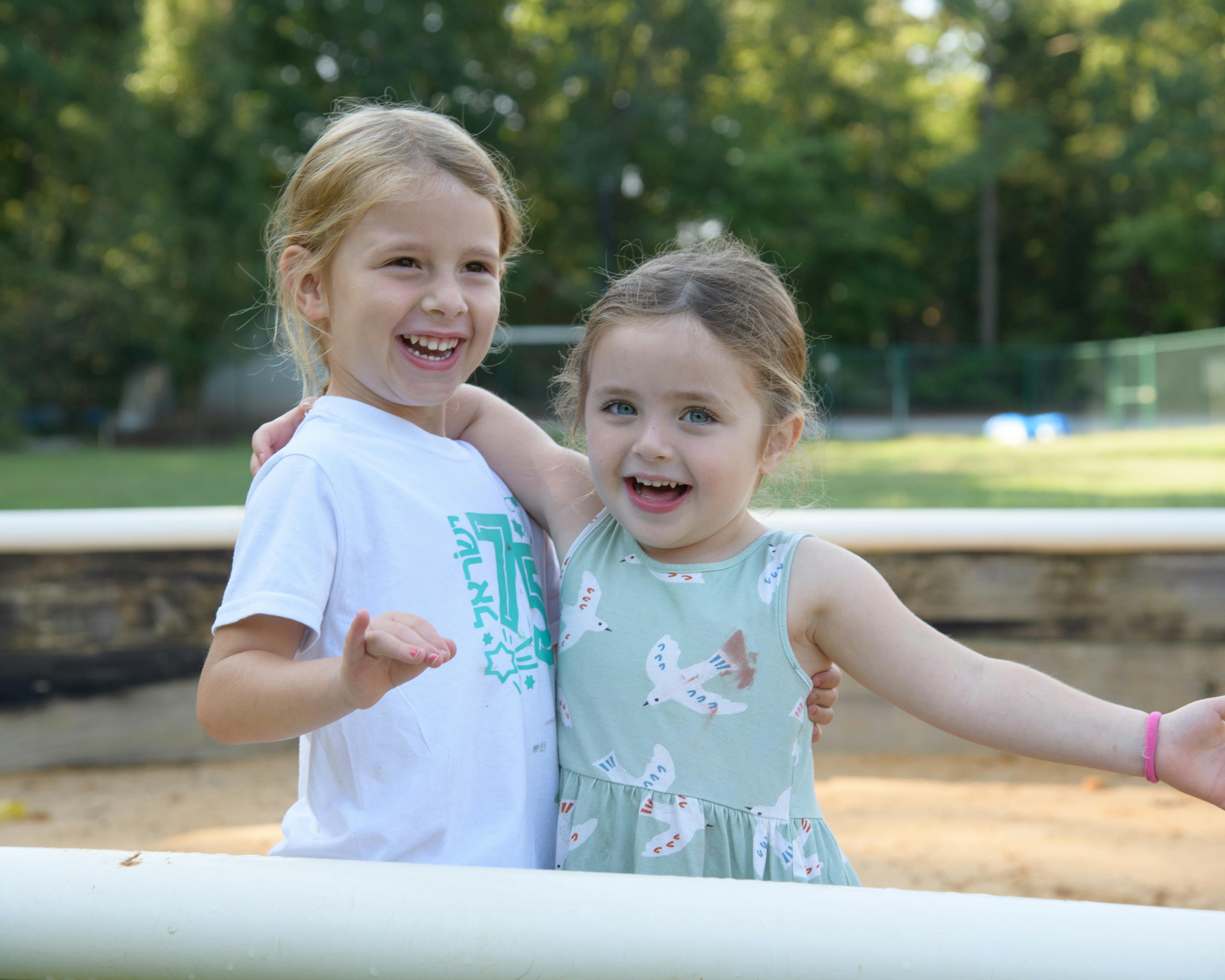Two children standing together with arms around each other