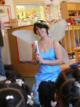Person in fairy costume with wings and flower crown holding a wand