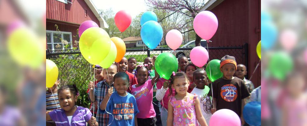Group of children holding colorful balloons outdoors