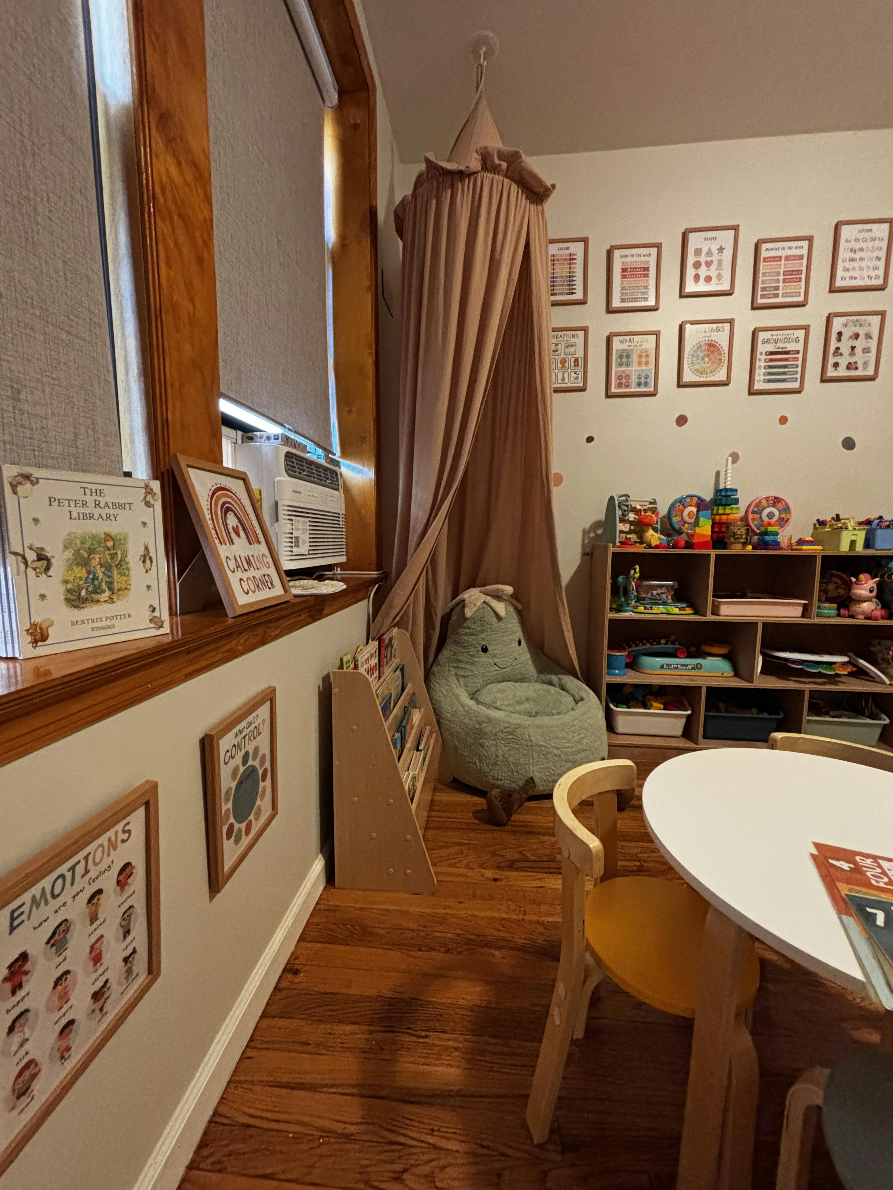 Child's playroom with a fabric canopy, plush chair, and educational wall art