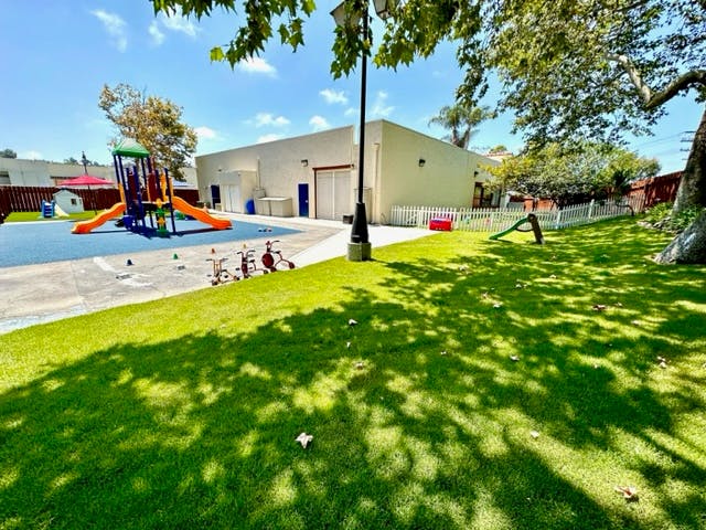 Playground with slides and climbing structure next to a grassy area