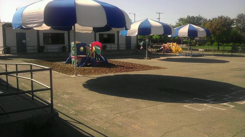 Blue and white striped umbrellas over a playground area