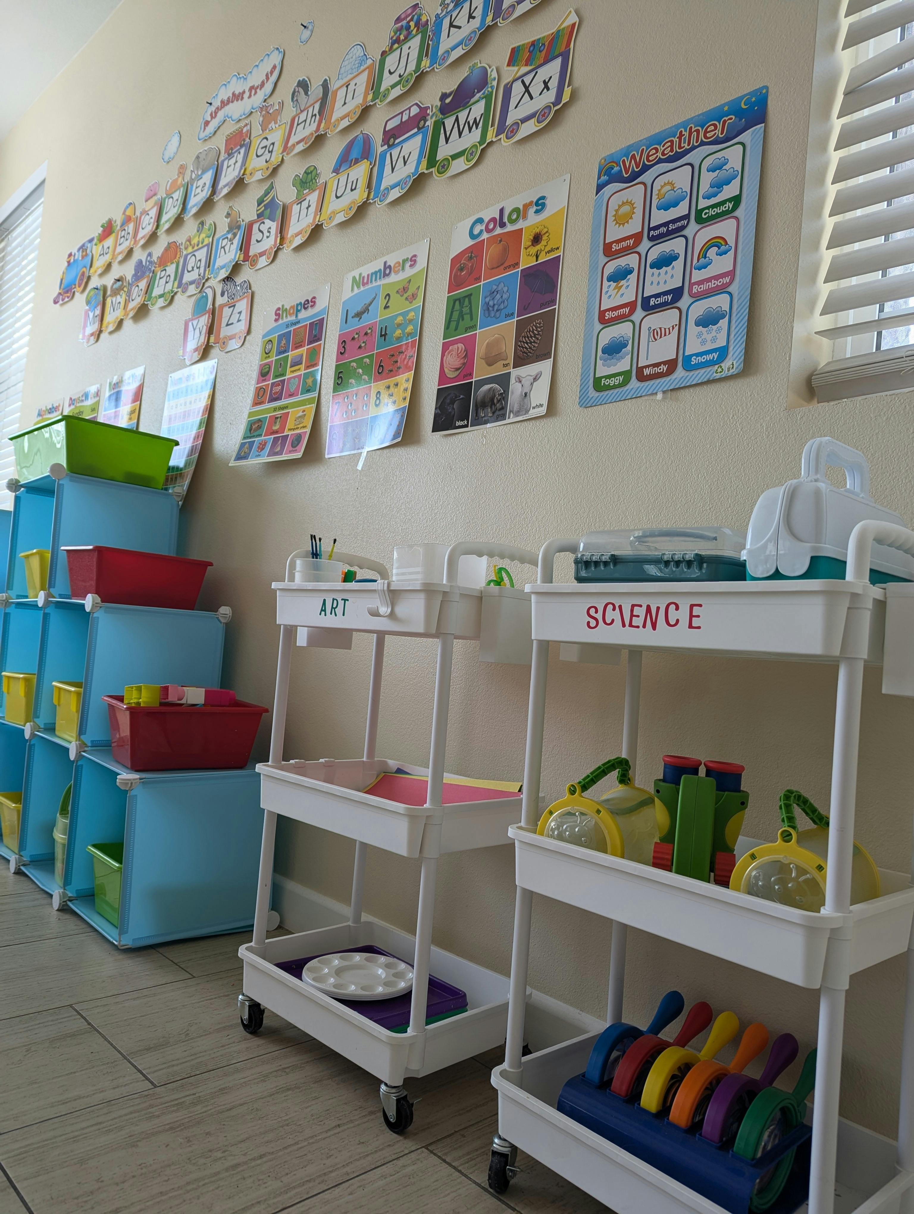 Classroom with educational posters and storage carts with learning materials