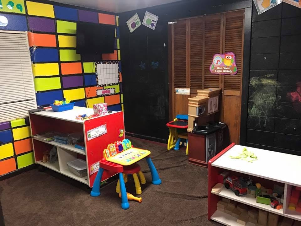 Playroom with colorful walls, small tables, and storage shelves