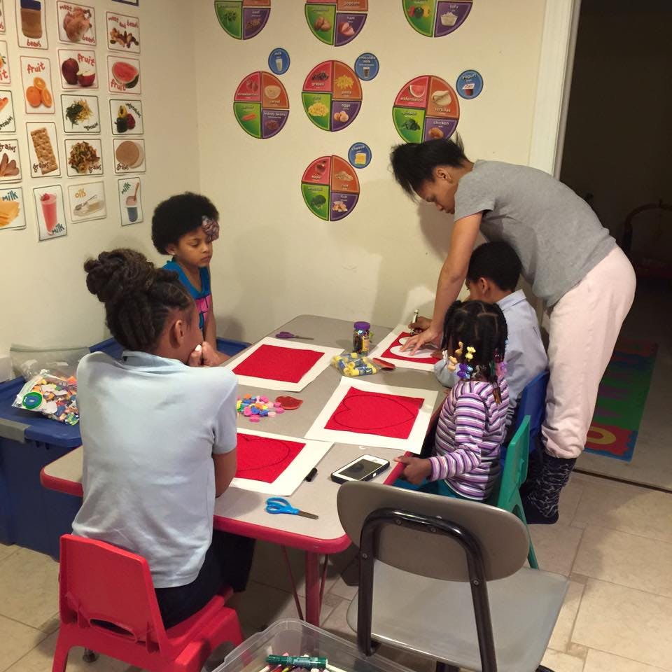 Adult and children at a table with craft supplies