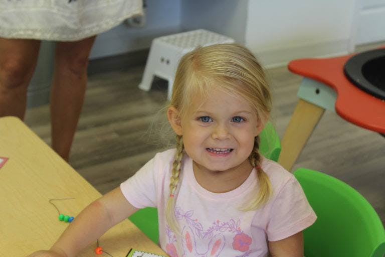 Child with blonde braids sitting at a table