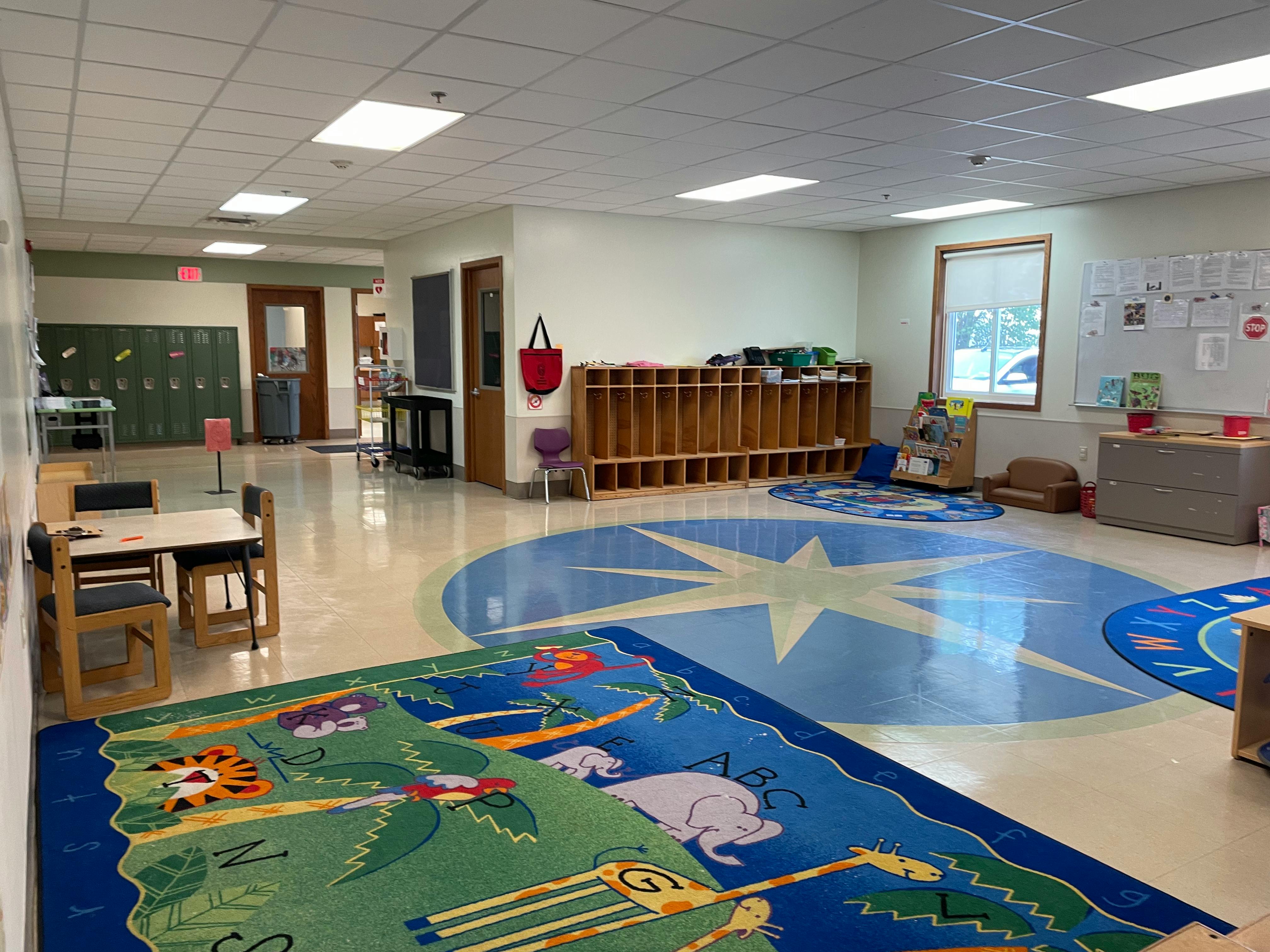 Empty classroom with colorful rugs and cubbies