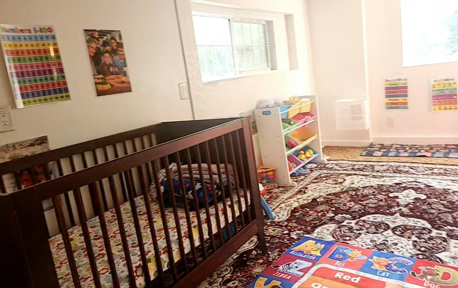 Crib in a child's room with educational posters and floor mats