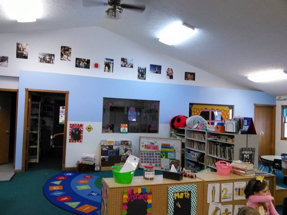 Classroom with blue and white walls, bookshelves, and a colorful rug