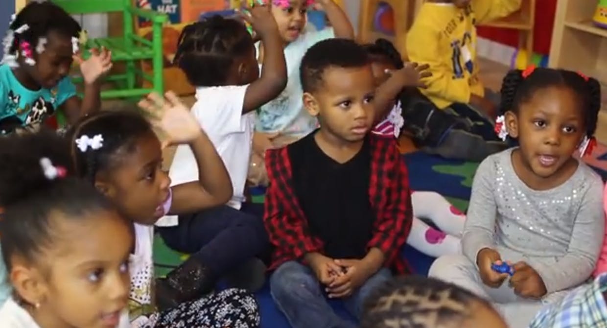 Group of children sitting on the floor in a classroom