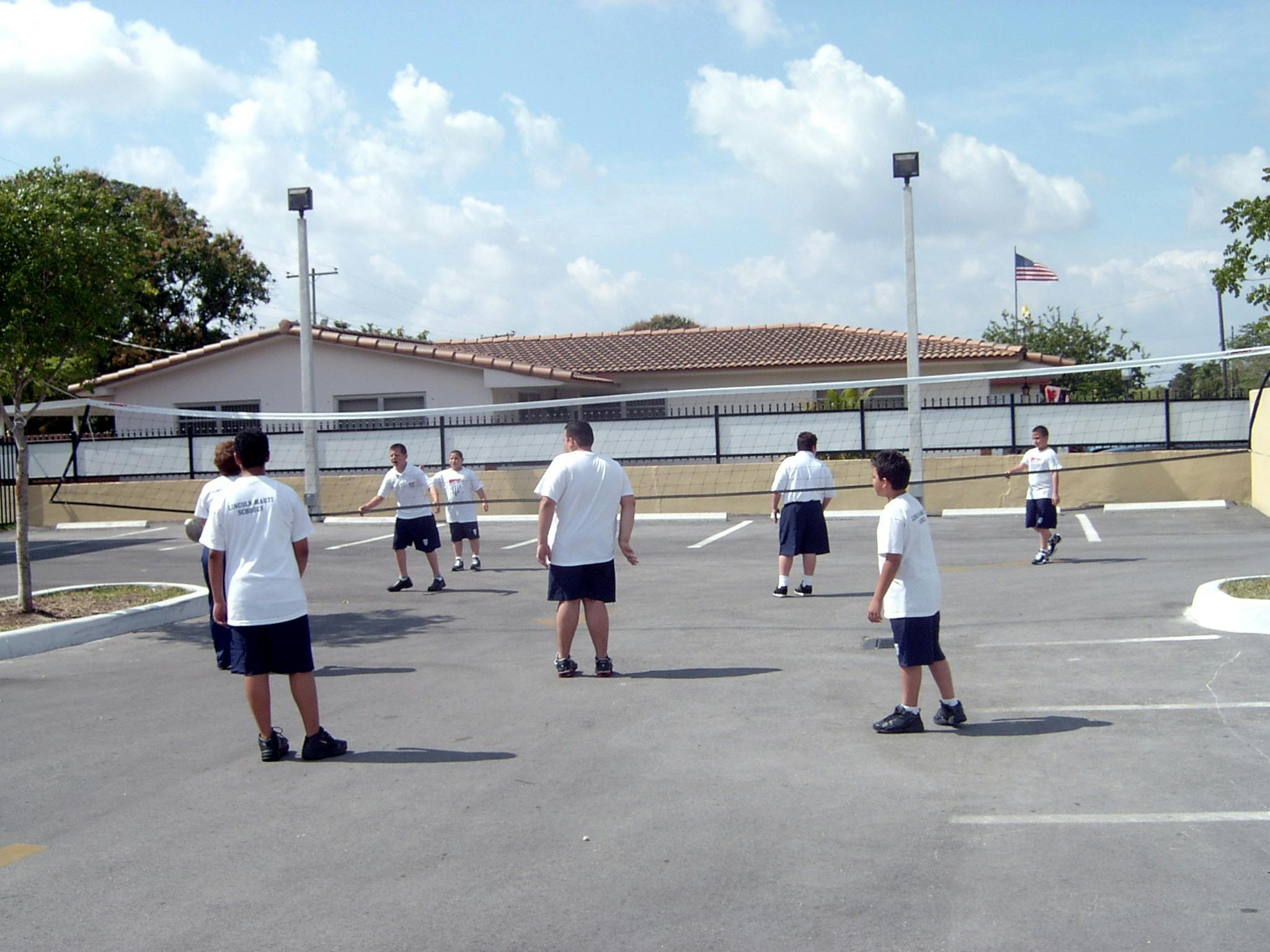 People playing volleyball in a parking lot