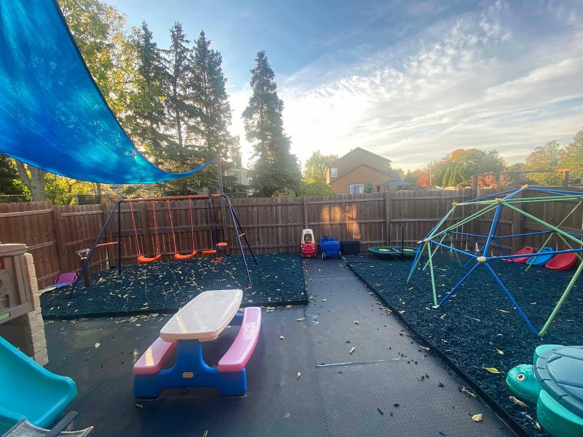 Outdoor playground with swings, climbing dome, and picnic table