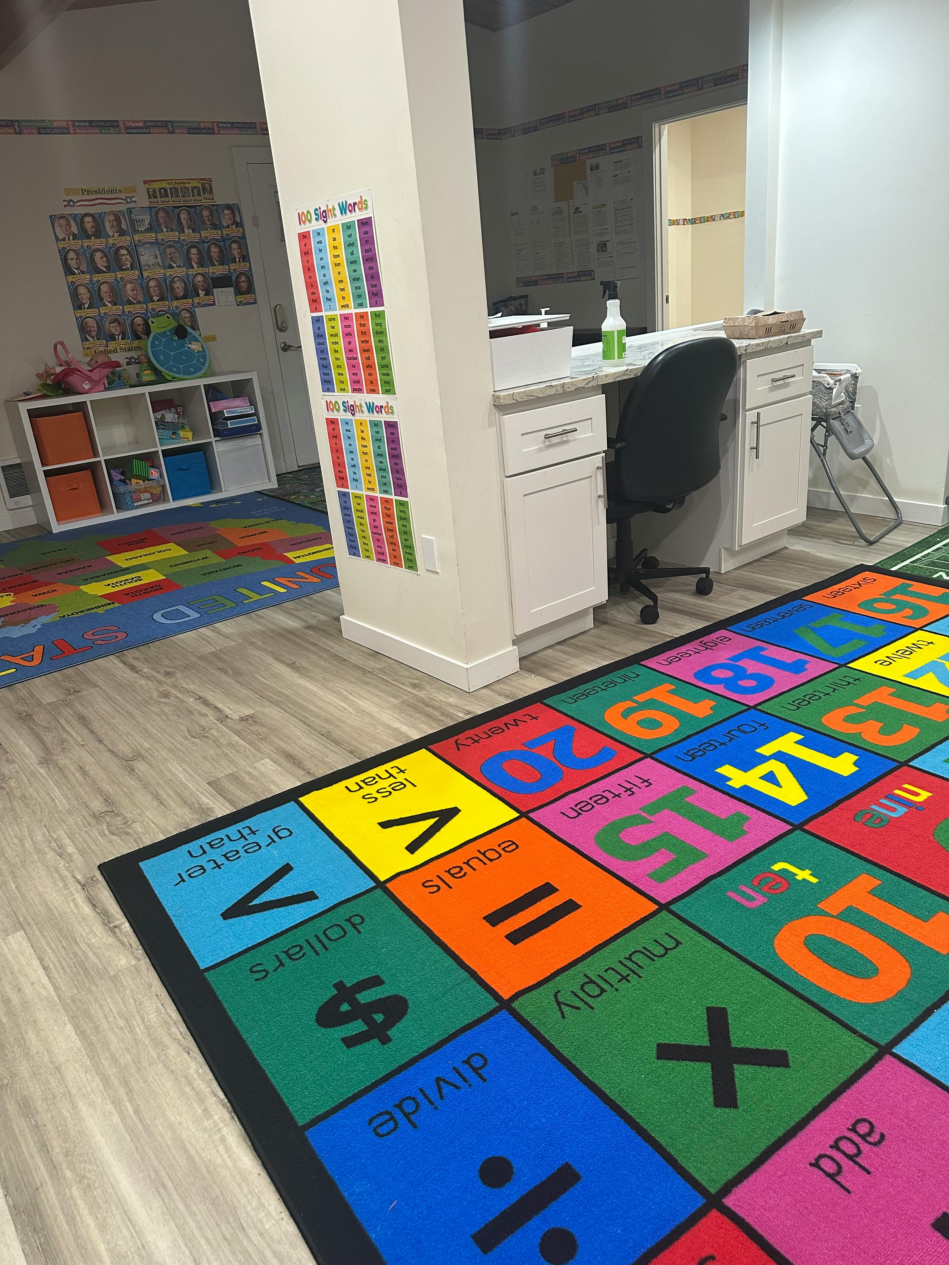 Colorful educational rug with numbers and math symbols in a room with a desk and shelves