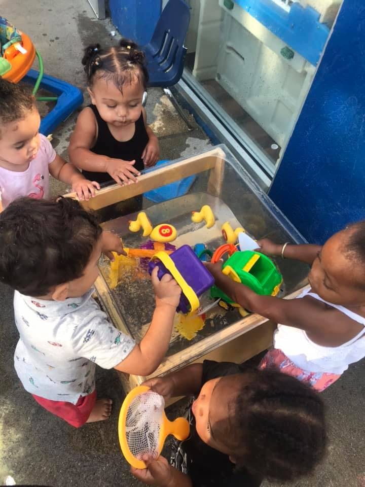 Children playing with toys in a water table