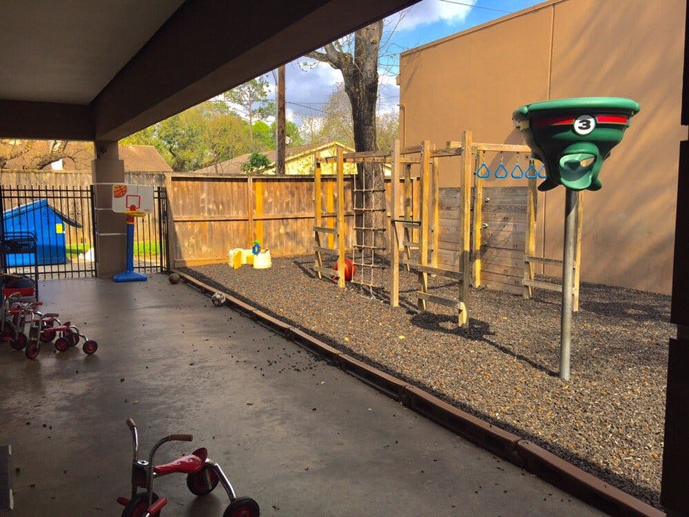 Outdoor playground with climbing structure and tricycles