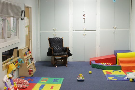 Playroom with a rocking chair, soft play equipment, and toys