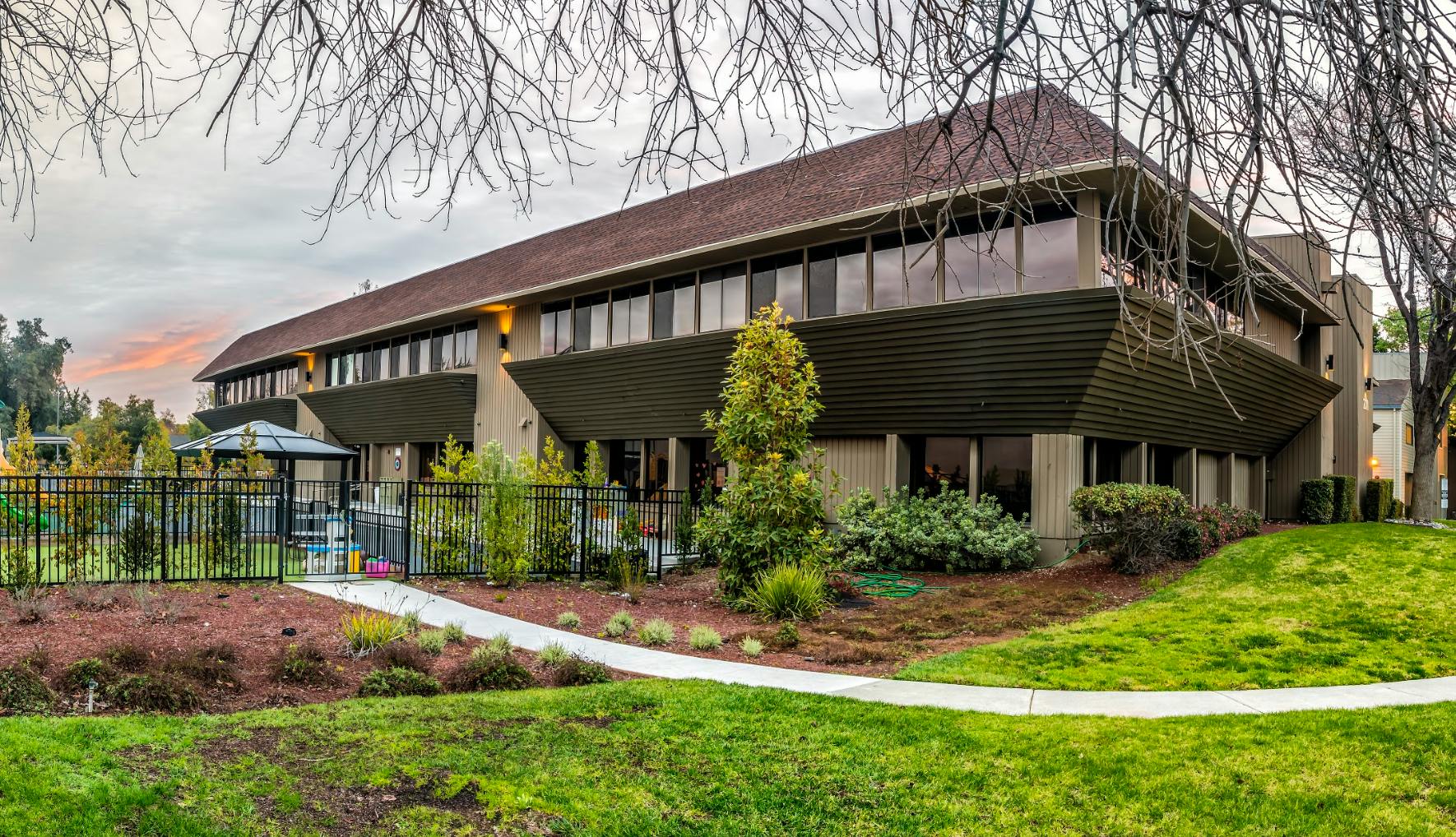 Exterior of a commercial building with a fenced playground area