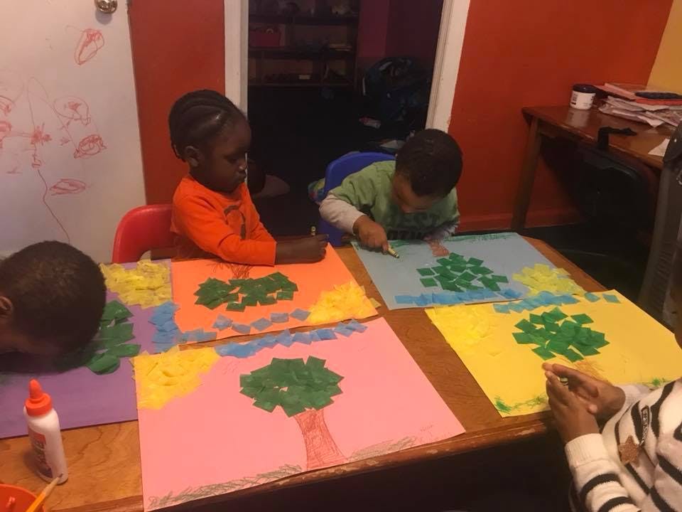 Children making tree art with paper cutouts