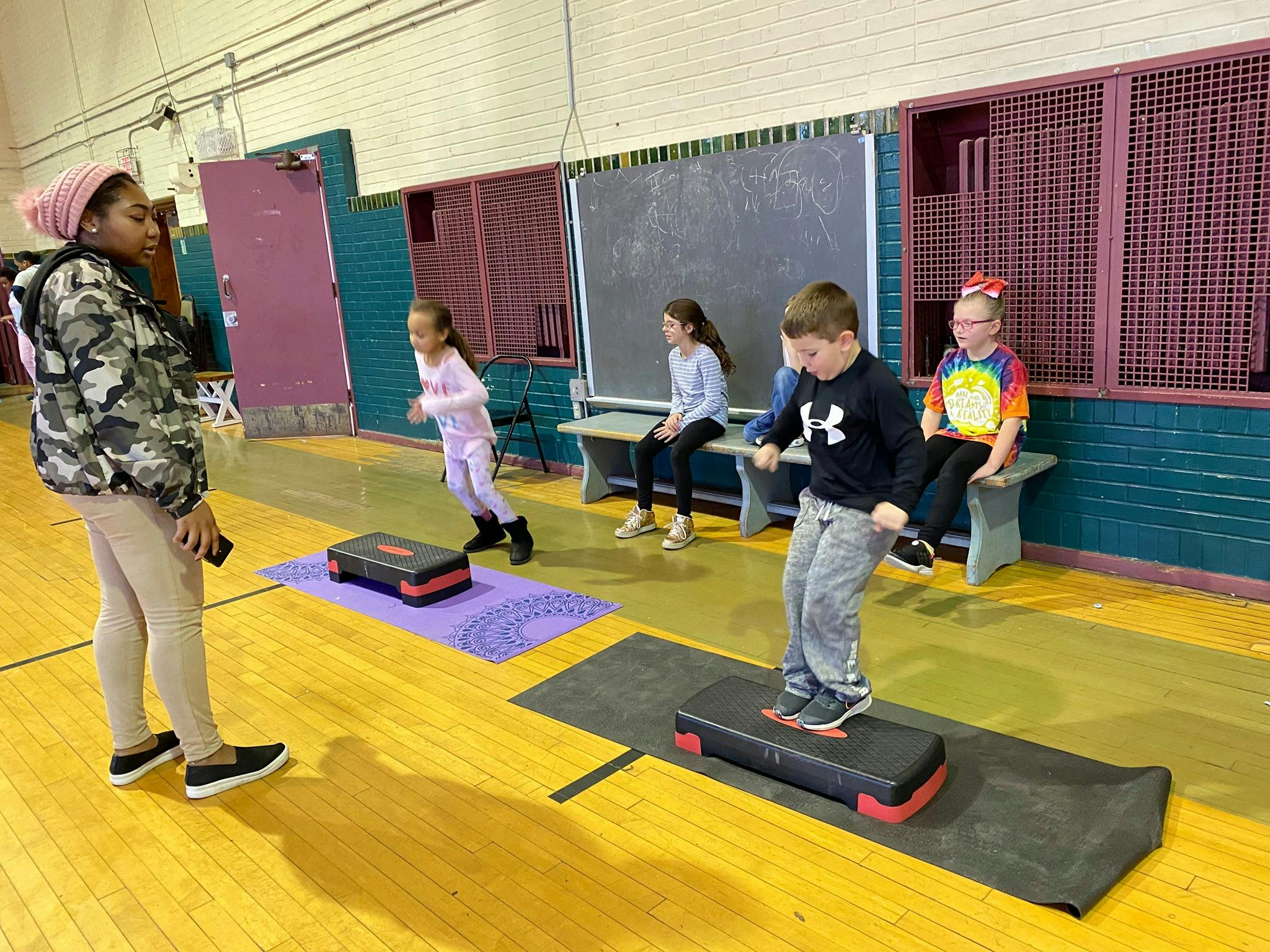 Children exercising with step platforms in a gym