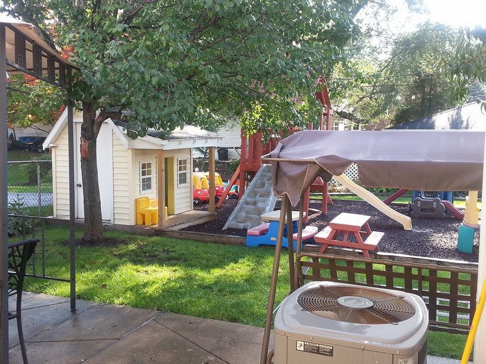 Backyard with a small playhouse and a playground set