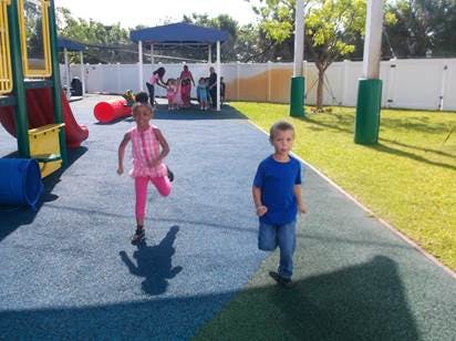Two children running on a playground