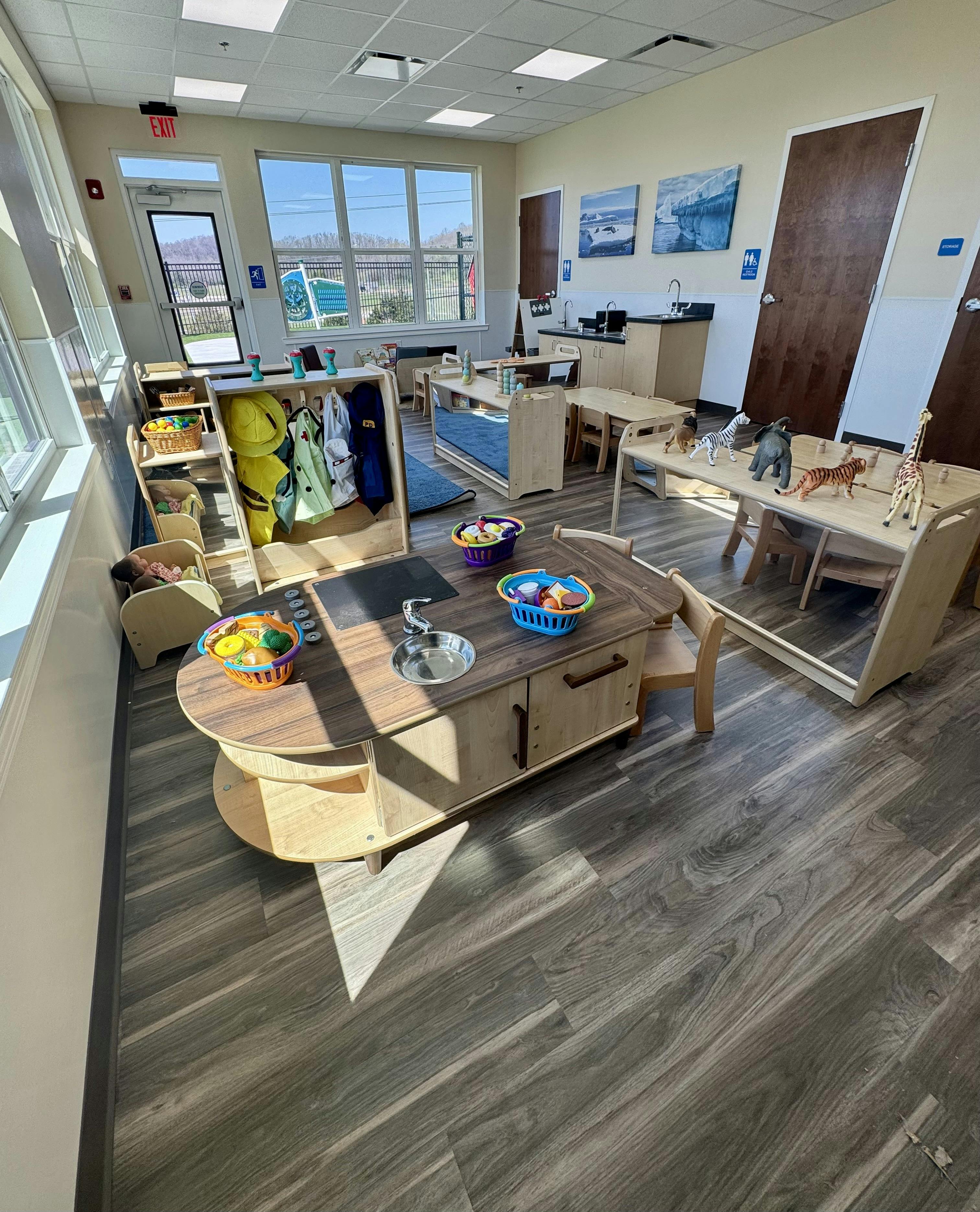 Playroom with child-sized furniture, kitchen playset, and animal figurines