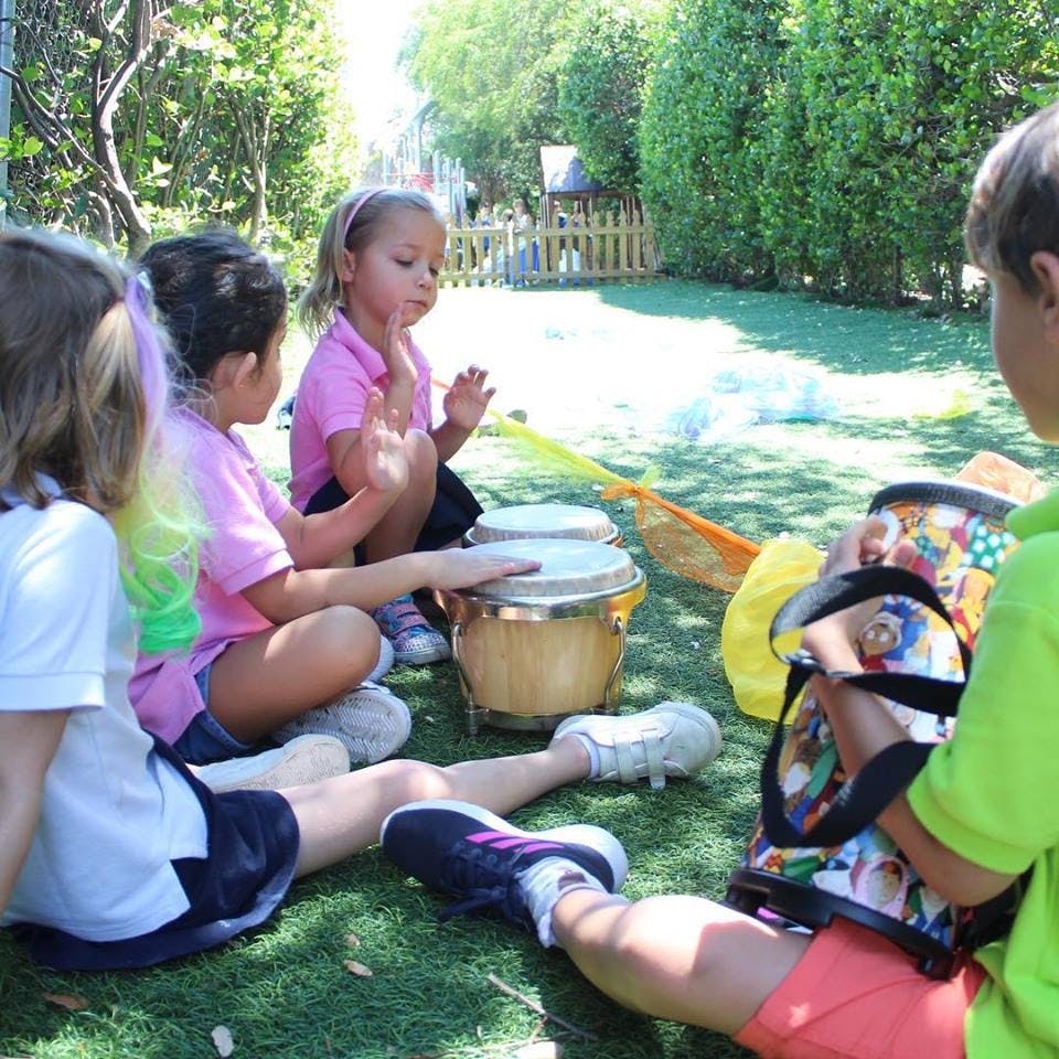 Children playing drums outdoors