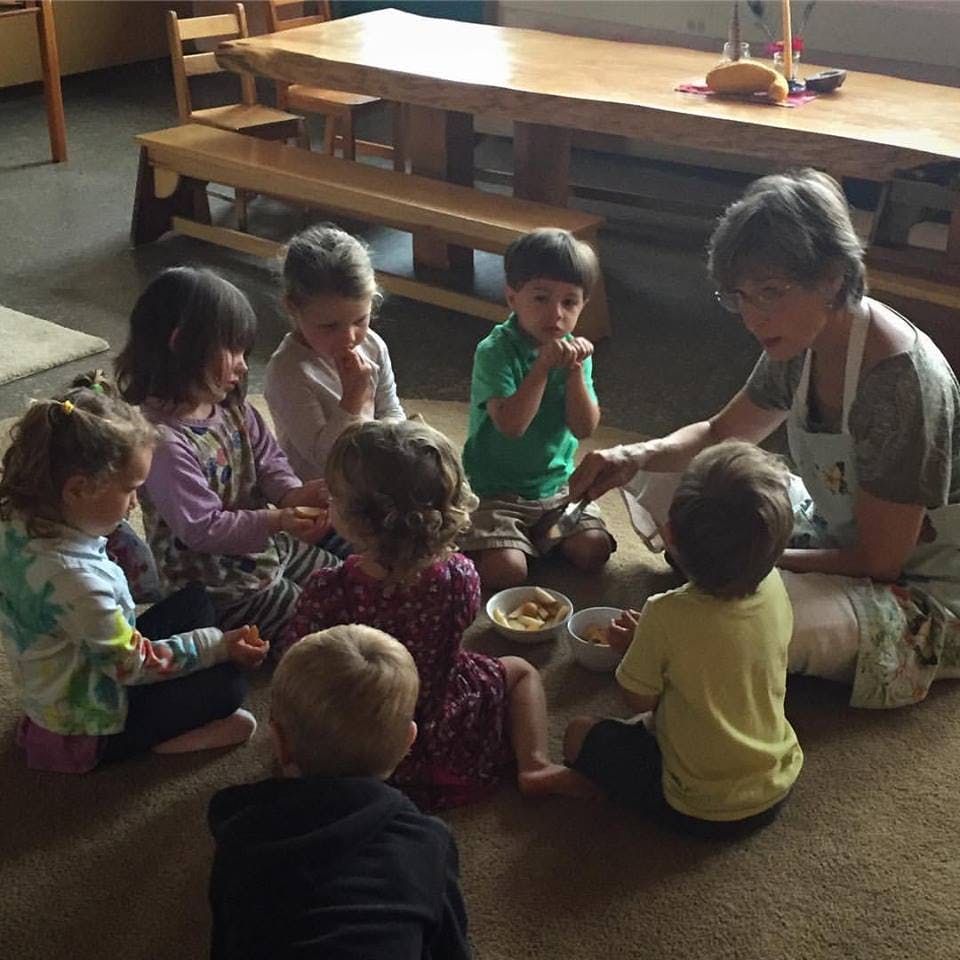 Adult and children sitting in a circle on the floor