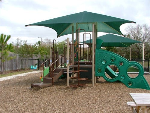 Playground with green shade covers, slides, and climbing structures