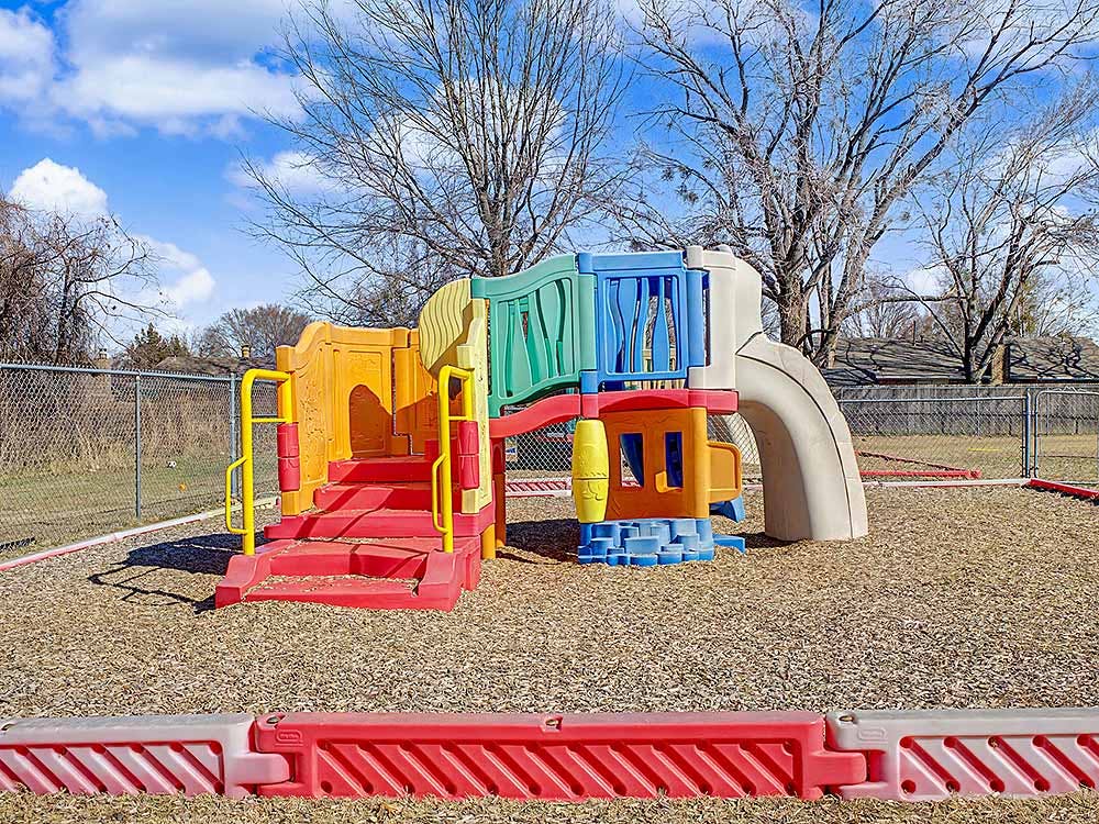 Colorful outdoor playground structure with steps and slide on wood chips