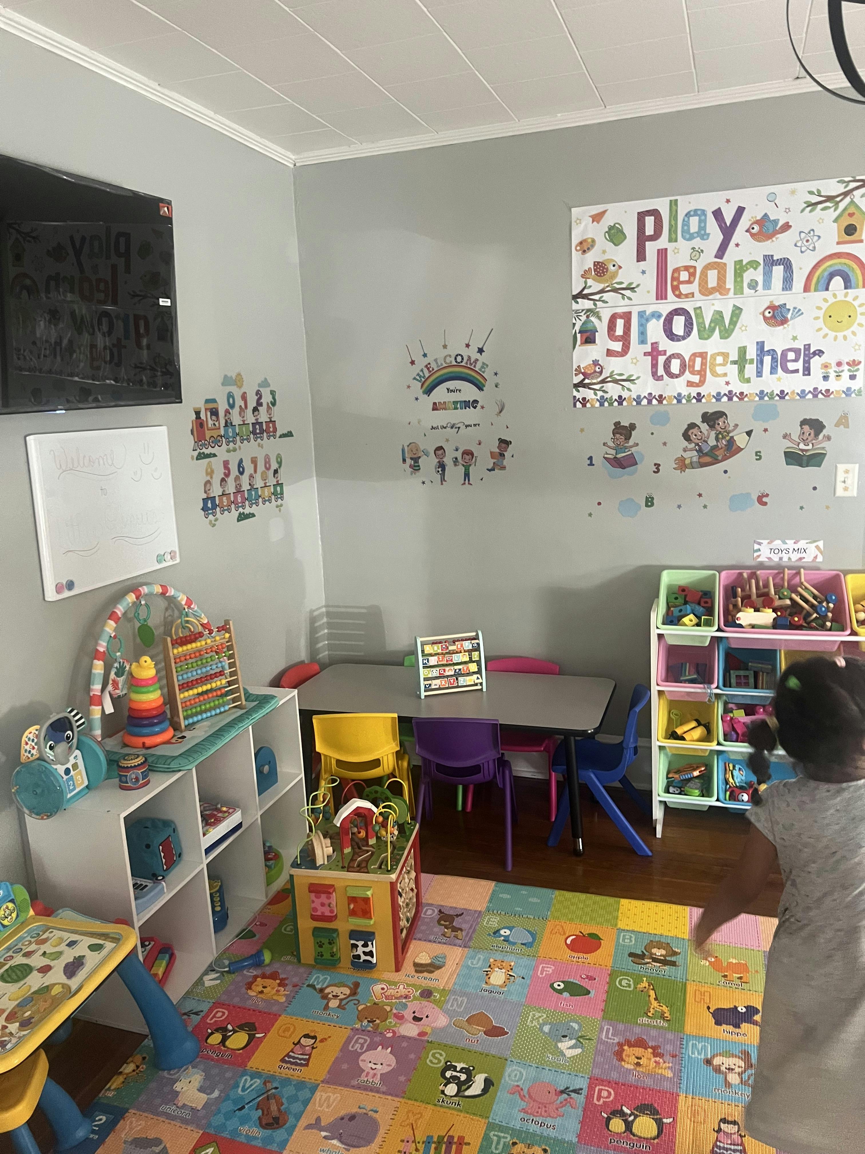 Child's playroom with colorful rug, toys, and small table with chairs