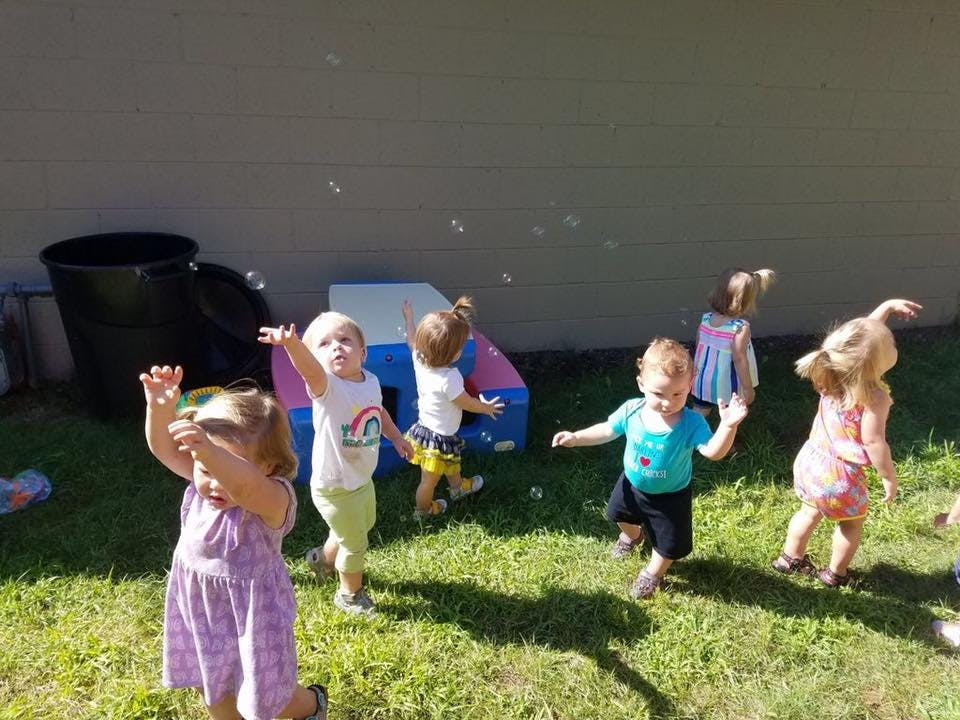 Children playing outdoors with bubbles
