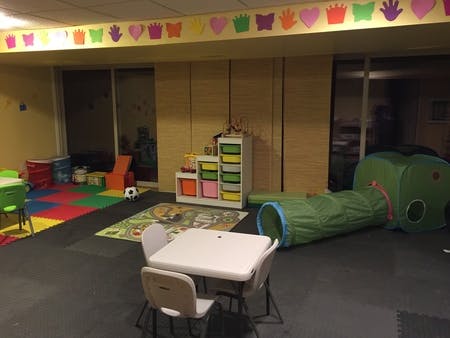 Playroom with small table and chairs, play tunnel, and storage unit