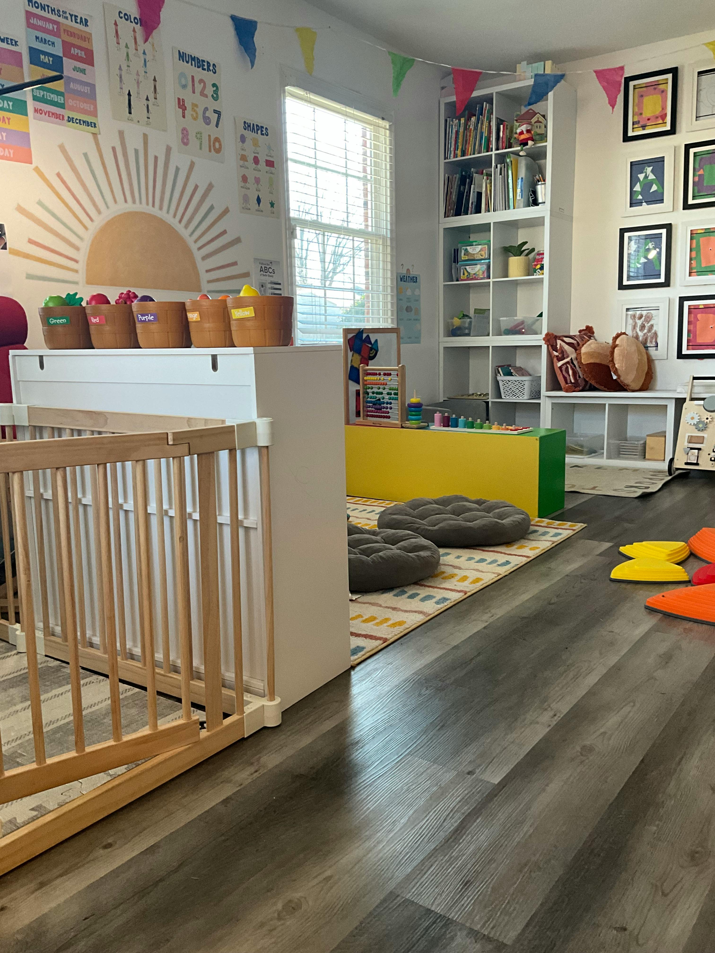 A playroom with a wooden crib, colorful posters, and bookshelves